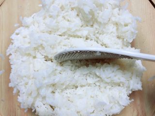8、西兰花芝士饭团,用勺竖着将米饭和寿司醋拌均匀。