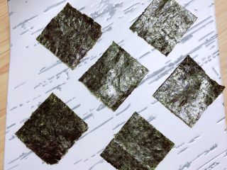 19、西兰花芝士饭团,将小块儿的寿司海苔摆放在盘中。