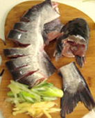 1、大蒜泡椒焖鲇鱼,先将鱼洗净,里面的筋膜取出,将头和鱼尾切断,鱼身且成等量的花刀状,不要切断。葱,姜,蒜,备好。