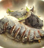 2、大蒜泡椒焖鲇鱼,锅中入油,先放入大葱,葱白,生姜爆香,接着放入鱼头,鱼尾,鱼身略微煎一下。