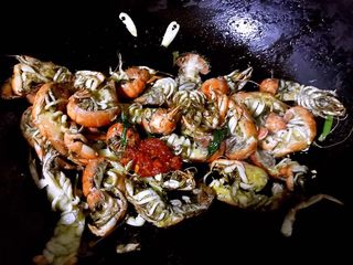 4、孜然粒炒蝼蛄虾,放入蒸好的蝼蛄虾同时放入蒜蓉辣椒酱和孜然粒大火快速翻炒