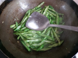 7、四季豆炒肉丝,加入一勺盐翻炒