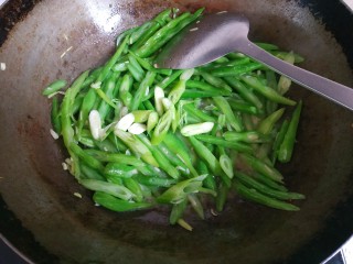 9、四季豆炒肉丝,放入葱翻炒