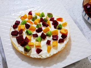 15、艾莎生日蛋糕,然后取一份蛋糕片,涂抹上奶油,放入水果,再盖上另一片蛋糕片,再涂抹上奶油