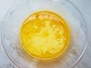 2、亚麻籽戚风蛋糕,蛋清先放在一边，用手动打蛋器将蛋黄搅打均匀，加入牛奶和玉米油，搅打至蛋黄、牛奶和玉米油完全融合。