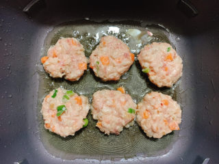 16、莲藕饼,中火控温,将面糊捏压成扁平的小饼,放入锅中。