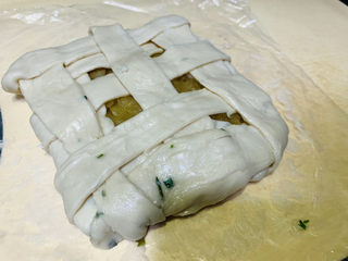 12、苹果饼,底部的手抓饼先包一圈,再取一个手抓饼,用剪刀剪成一条条,交错覆盖在苹果泥上,并包住底部;