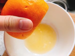 3、橙子蒸蛋-12m➕宝宝辅食,用手轻轻挤出少许橙汁到干净的碗里，备用。（用劲过大橙皮会破）