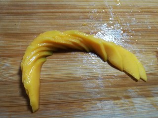 14、#辅食计划#~芒果酸奶杯,然后如图往两头推开，因为芒果肉具有一定的粘性，一片片会粘合在一起不会倒掉。