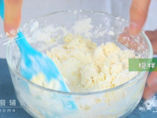 5、橙汁磨牙饼干,搅拌成絮状，倒在揉面垫上揉光滑。