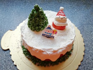 27、圣诞奶油蛋糕,插上装饰卡片，给圣诞树和圣诞老人上面均匀的撒上一些椰蓉，圣诞奶油蛋糕就完成了。