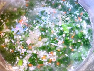 8、猪肝时蔬粥,放入芹菜叶煮1至2分钟时间不要过久即会影响口感也会不美观哦放入盐和味精调味均匀即可享用