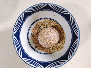 8、紫薯芝麻饼,把紫薯糯米团放入芝麻碗里滚一圈