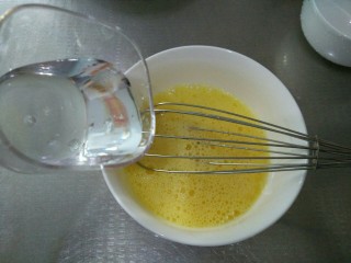 4、虾仁蒸蛋羹,蛋液用蛋抽搅打均匀，加入2倍的凉开水。一定要用凉开水或者温开水，不要用冷水哦！不然也容易有气孔。