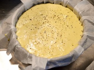 16、法式咸派【魔法蛋糕】,倒入模具，表面轻轻抹平，再撒一些黑胡椒碎，就可以进烤箱烘烤了。温度转150℃，50分钟。大烤箱中层，小烤箱中下层。表面开始上色后可以加盖锡纸