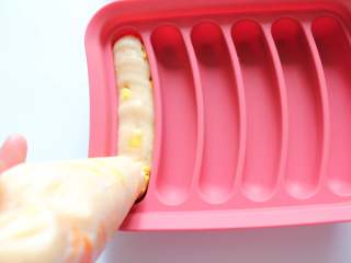 9、自制宝宝鸡肉蔬菜肠（适合24个月以上的宝宝）,用剪刀将裱花袋剪去一个口，稍微用力挤压裱花袋，将肉馅挤到模具中