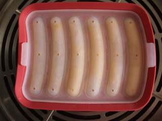 10、自制宝宝鸡肉蔬菜肠（适合24个月以上的宝宝）,将挤好的鸡肉肠模具盖好，放入到蒸锅中火蒸18分钟左右