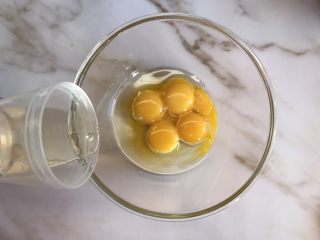 2、八寸戚风蛋糕,五个蛋黄打入碗中加入玉米油