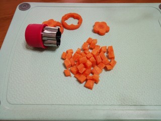 4、#宝宝辅食#鳕鱼胡萝卜香菇粥,4.胡萝卜去皮,切丁,两片胡萝卜印成花朵形状。