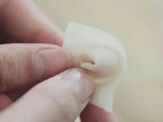 12、快手小馄饨,馄饨皮里放入少许肉馅，对折后两个角向内折叠。