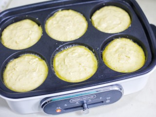 8、奶香南瓜饼,放入多功能锅的模具中，上面撒少许黑芝麻，一面成型后翻面。