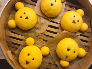 12、小熊馒头,发酵好后将眼睛鼻子放在小熊合适位置，取适量可可面团揉长条当小熊嘴巴