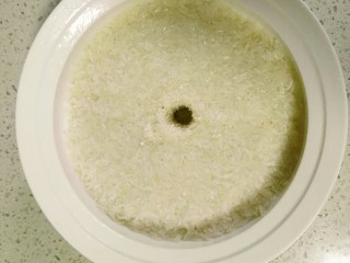 11、自酿米酒,拌匀后抹平，在中间开个酒窝。剩余的2克酒曲放入酒窝中。盖上盖子，放在温暖处进行发酵，所有的一切就交给时间啦。