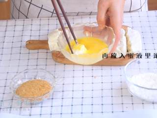 2、炸牛奶,再放入蛋液里滚一圈,奶块裹上面包糠。