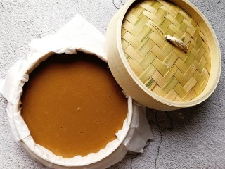 8、快手红糖马拉糕,将马拉糕糊倒入铺好油纸的蒸笼内,盖上蒸笼盖子静置20分钟