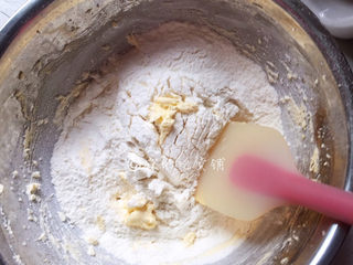 5、冬至美食 奶酪夹心饼干,用橡皮刮刀翻拌，使黄油和低粉混合均匀。