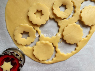 7、冬至美食 奶酪夹心饼干,面团取出后，用擀面杖擀成约0.3厘米厚的面皮，再用饼干模具刻出花型。
