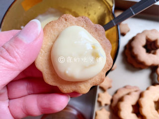 11、冬至美食 奶酪夹心饼干,取一块饼干，先铺上一层乳酪。