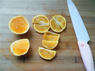 2、橙香费南雪,用锋利、抗氧化的奈瓷刀将橙子对半切开，中间漂亮的部分切4片，再将4片对半切。