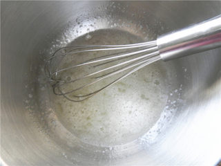 7、橙香费南雪,取70克蛋清，加入糖粉，搅拌到糖融化，用手抽打至粗泡阶段。