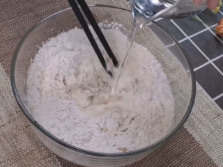 3、梅干菜烧饼,所有材料全都加入面粉中,一定要注意的是和面一定要用温水,温度高了酵母菌会失活,温度低了,发酵时间长。可以用手试试温度,跟体温差不多就可以了。