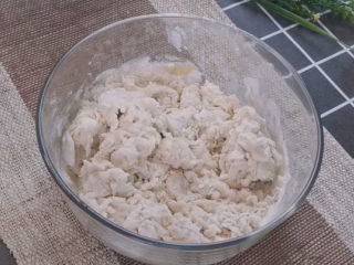 4、梅干菜烧饼,先用筷子把面粉搅成絮状,再上手揉成光滑的面团