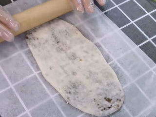 13、梅干菜烧饼,然后用擀面杖擀成薄片,我做成了牛舌状的,你也可以做成圆形的,都是可以的。