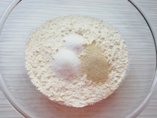 1、火腿彩蔬披萨,高筋面粉中加入发酵粉、盐和糖混合均匀。