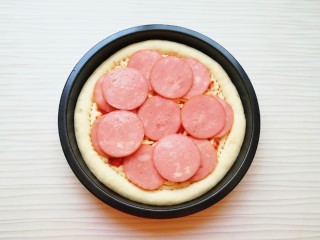 8、火腿彩蔬披萨,铺上火腿肠片。