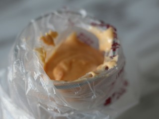 8、网红胡萝卜奶香网格蛋饼,将裱花袋套在玻璃杯上，把面糊倒入裱花袋中。