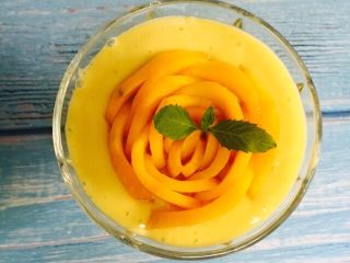 18、芒果香蕉奶昔,将芒果花轻轻放入杯子，薄荷叶装饰