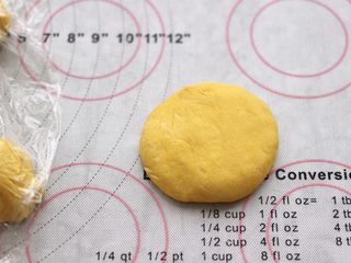 11、南瓜酸奶华夫饼,盖保鲜膜松弛10分钟后，取一个面团摁扁。