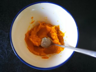 5、千层手撕南瓜馒头,蒸好的南瓜用勺子压成泥,趁热加入白糖使其融化。