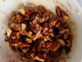 3、碧根果可可脆,倒入果仁混合均匀，每颗碧根果都裹满巧克力酱。