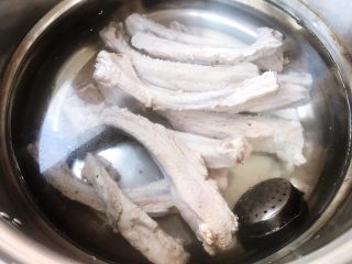 6、手扒排骨,锅中倒入适量清水放入猪肋排和调味罐大火炖起来