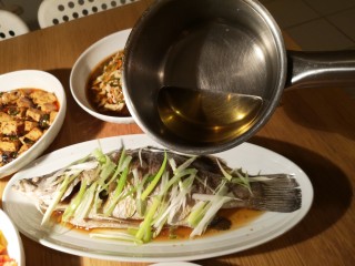 8、清蒸盲曹鱼,加入热油。淋上蒸鱼豉油。