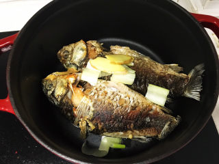 7、奶白鲫鱼豆腐汤,放入葱段和姜片;