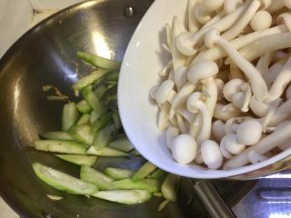 5、丝瓜烩白玉菇,加入白玉菇，翻炒，淋入少许料酒，翻炒均匀。白玉菇有种特殊的香味，如果不适应，可以先焯水再炒