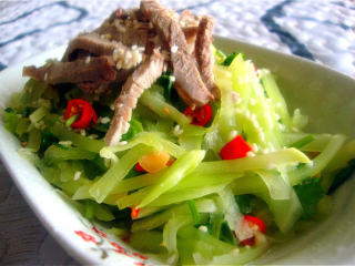 5、傣族风味菜：凉拌莴笋丝,装盘，放上肉丝，撒芝麻。吃的时候再拌一下就可以