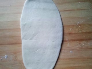 4、#千花万蕊待食来#    香菜鸡蛋灌饼,将醒发好的面团再次揉好，切剂子，压扁，擀成牛舌状。